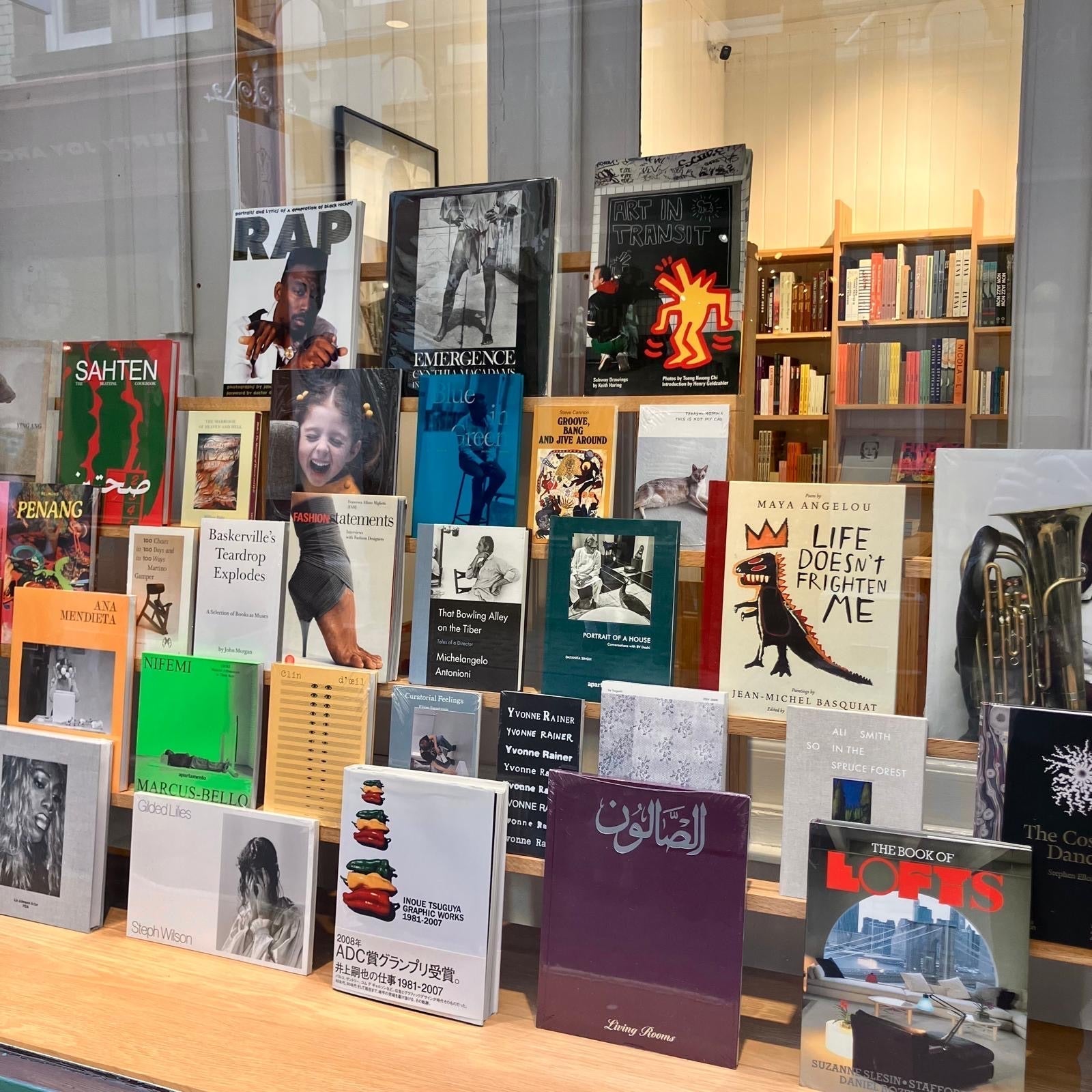 A collection of art and photography books displayed in a bookstore window.