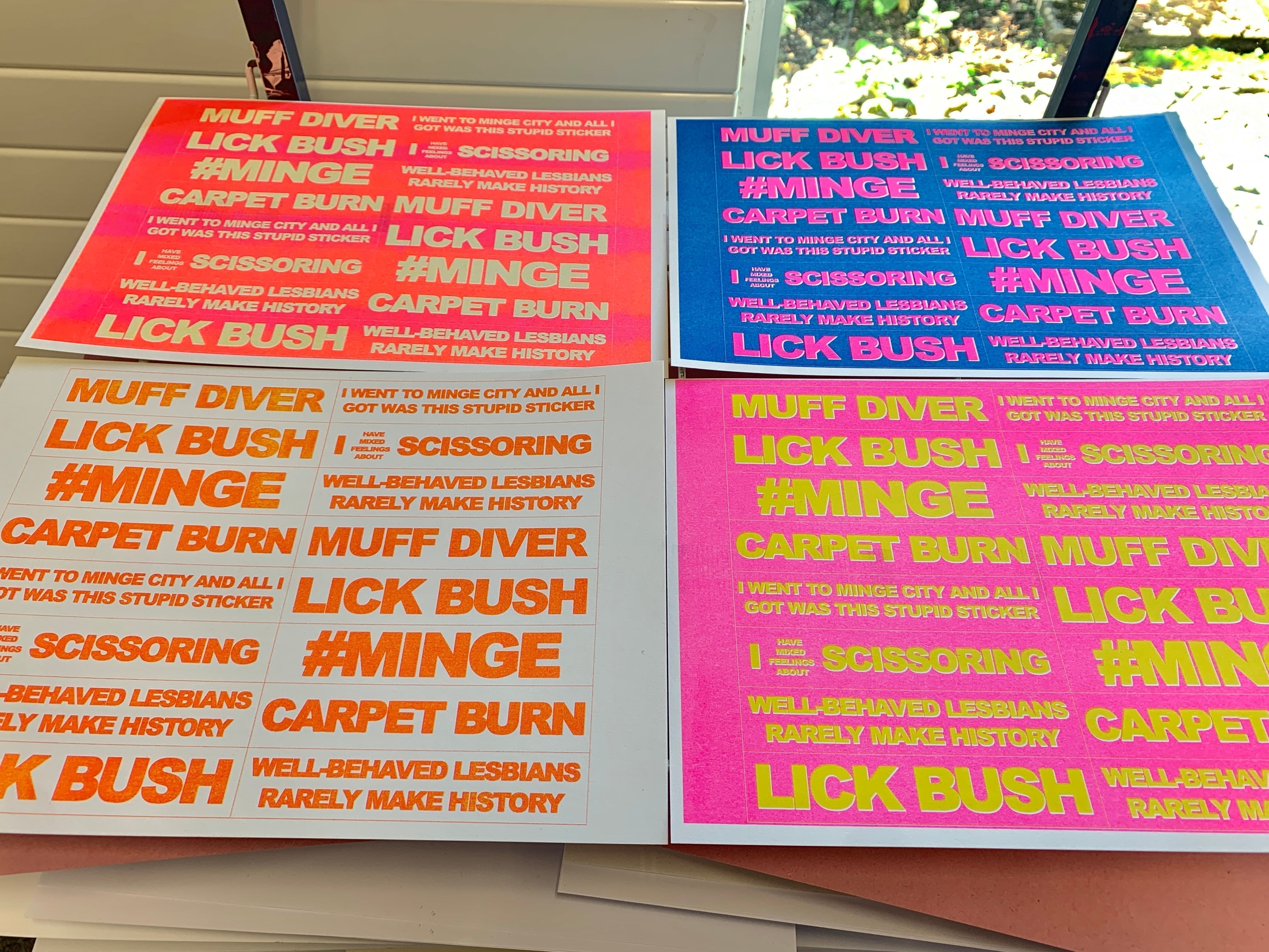 Four brightly colored prints featuring repetitive typographic text in red, pink, and orange.