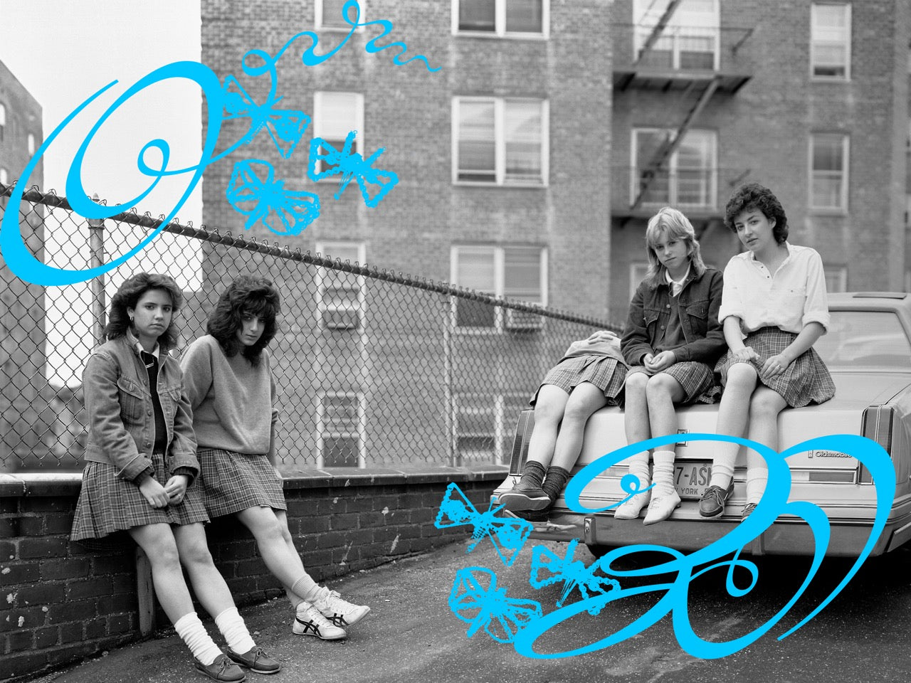 Black and white photo of three girls on a rooftop with blue scribbles over the image.