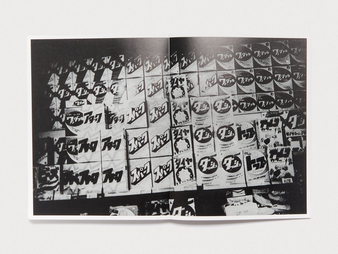 Interior spread of a photography book featuring a black and white collage of Japanese signage.