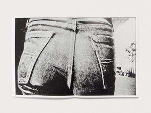 Black and white photograph of the back of a person wearing denim jeans.