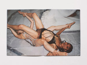 Interior spread from a photography book featuring an artistic composition of two intertwined bodies.