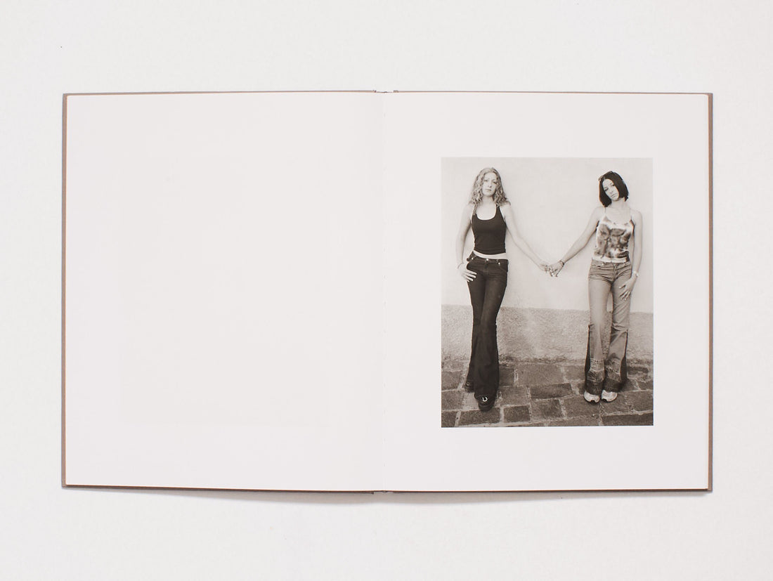 Interior spread showing a black and white photograph of two women holding hands.