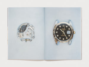 Interior spread showing a disassembled watch movement and a Rolex watch on a blue background.