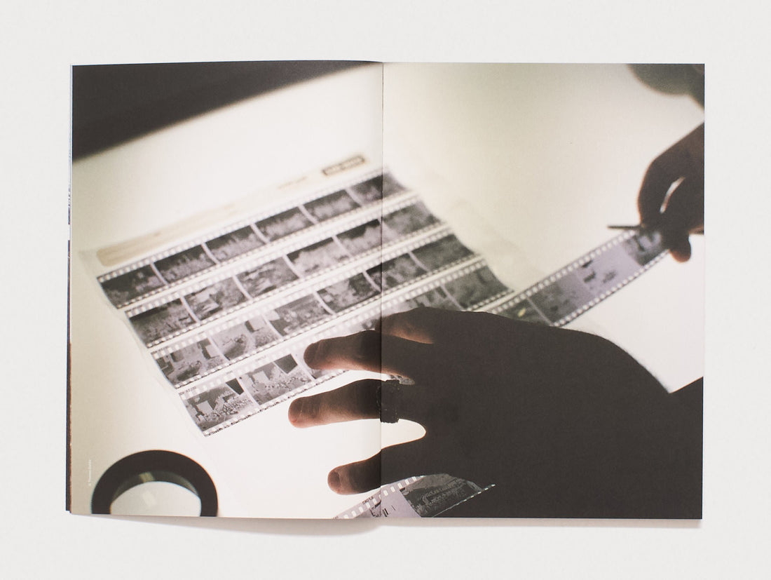 Interior spread showing hands sorting through photographic film strips.