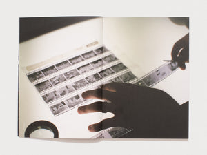 Interior spread showing hands sorting through photographic film strips.
