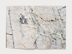 Interior spread showing three people rock climbing a light-colored cliff face.