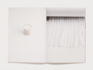 Interior spread showing a white container and a textured white surface.