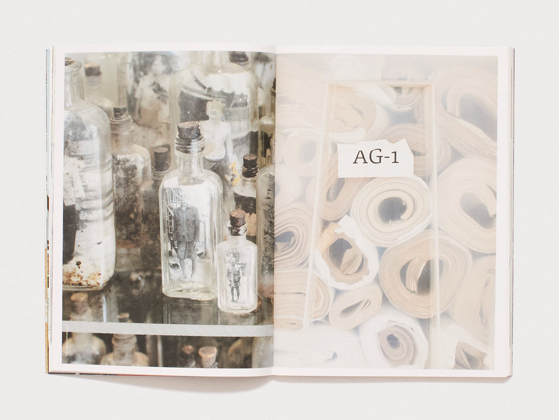 Interior spread featuring photographs of glass bottles and rolled papers.