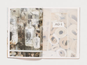 Interior spread featuring photographs of glass bottles and rolled papers.