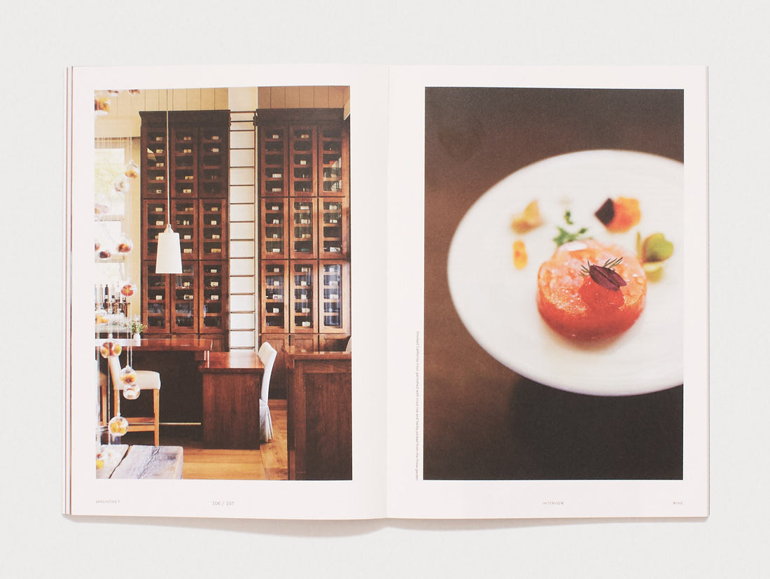 Interior spread showing a room with wooden cabinets and a plated gourmet dish.