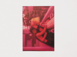 A red-tinted photograph of two people embracing in an outdoor setting.